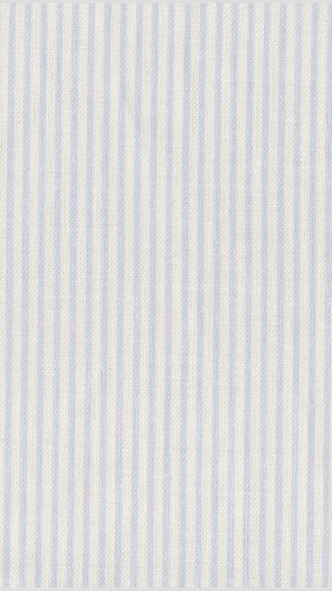 The image displays a close-up of a fabric surface with evenly spaced vertical stripes in a soft, pale blue hue against a creamy off-white background. The texture suggests a woven material, possibly cotton or linen, with a subtle, fine weave pattern visible between the stripes. The composition is uniform and repetitive, emphasizing the rhythmic pattern and tactile quality of the textile. There are no characters, actions, or environmental elements present, making it purely an abstract textile design. The lighting is even and neutral, highlighting the fabric's natural texture without casting shadows or creating contrast. The overall impression is one of calm, minimalist elegance, suitable for interior decor or background textures.