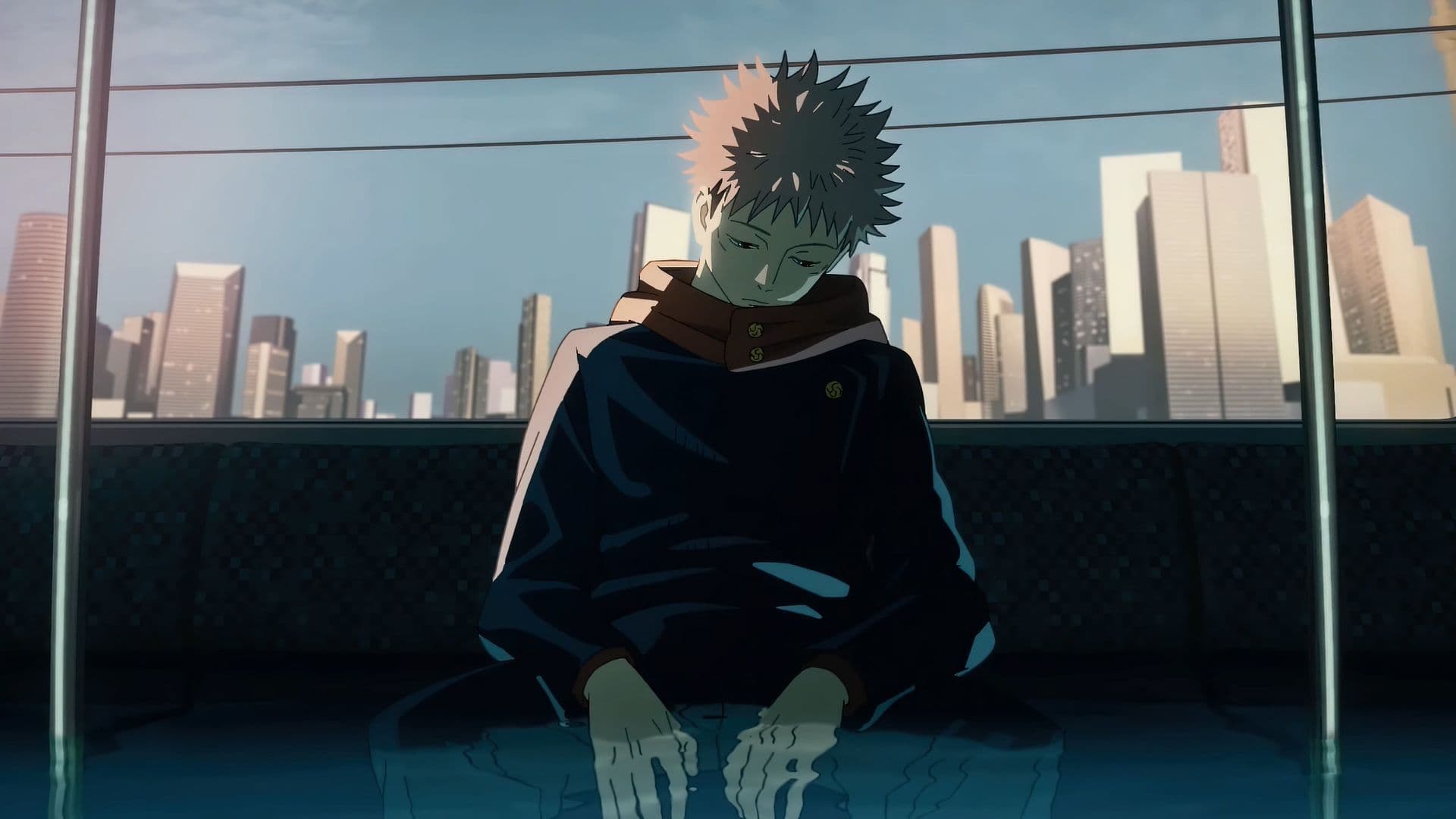 The image features Yuji Itadori, the protagonist of Jujutsu Kaisen, sitting in a somber, reflective pose. He is wearing his signature dark blue Jujutsu High uniform, characterized by a high red-lined collar and gold buttons, which provides full coverage. The character is seated on a train or bus, with his hands resting in a shallow pool of water that has accumulated on the floor, creating a surreal and symbolic effect. In the background, a sprawling urban skyline with numerous skyscrapers is visible through the window under a clear, bright sky. The artistic style utilizes sharp linework and cinematic lighting, with a strong contrast between the shadowed interior and the bright exterior. The overall atmosphere is deeply melancholic and introspective, suggesting a moment of quiet grief or heavy contemplation.
