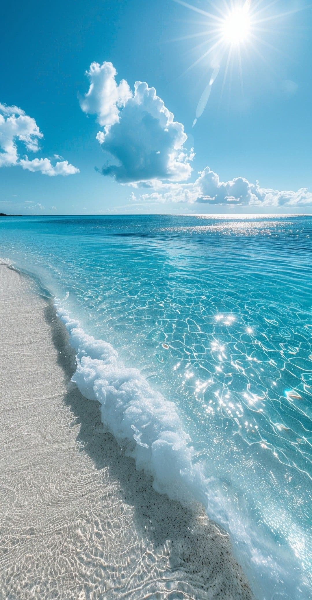 This image captures a serene coastal landscape under a bright, clear sky, featuring a pristine white sandy beach meeting crystal-clear turquoise waters. Gentle waves break softly at the shoreline, creating frothy white foam that contrasts with the transparent, sun-dappled water. The sun shines brightly from the upper left, casting radiant starburst effects and illuminating the scene with natural daylight, while scattered cumulus clouds add depth to the vivid blue sky. The composition emphasizes tranquility and natural beauty, with the shoreline curving gracefully into the frame, inviting calm contemplation. The water’s surface reflects light in shimmering patterns, enhancing the sense of peacefulness and untouched natural harmony.