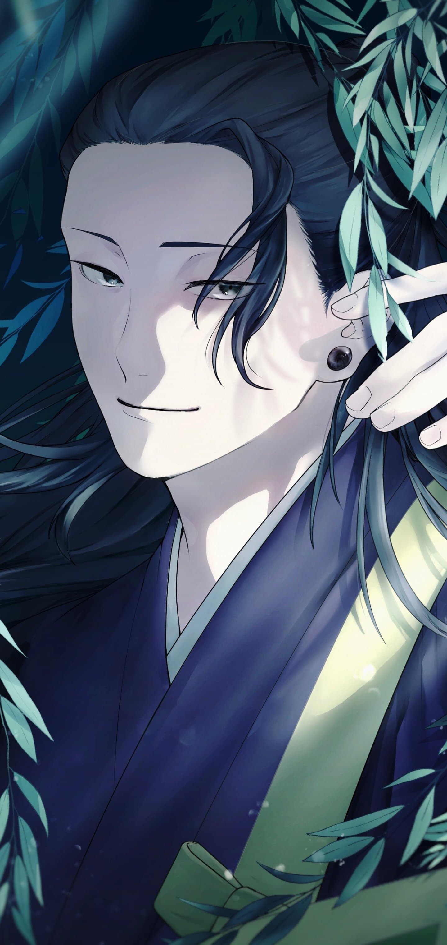 The image features a close-up portrait of Suguru Geto from Jujutsu Kaisen, characterized by his long dark hair and a single black gauge earring. He is dressed in traditional Japanese monk attire, specifically a dark blue yukata or kimono with a pale green sash visible across his chest. The character is depicted with a calm, subtle smile and narrow, intelligent eyes, looking slightly toward the viewer. He is framed by lush, dark green willow-like leaves that create a natural border around his face. The artistic technique utilizes clean digital lines and soft, dappled lighting that mimics sunlight filtering through a forest canopy. The overall atmosphere is serene and contemplative, with a touch of mystery provided by the deep shadows and cool color palette.