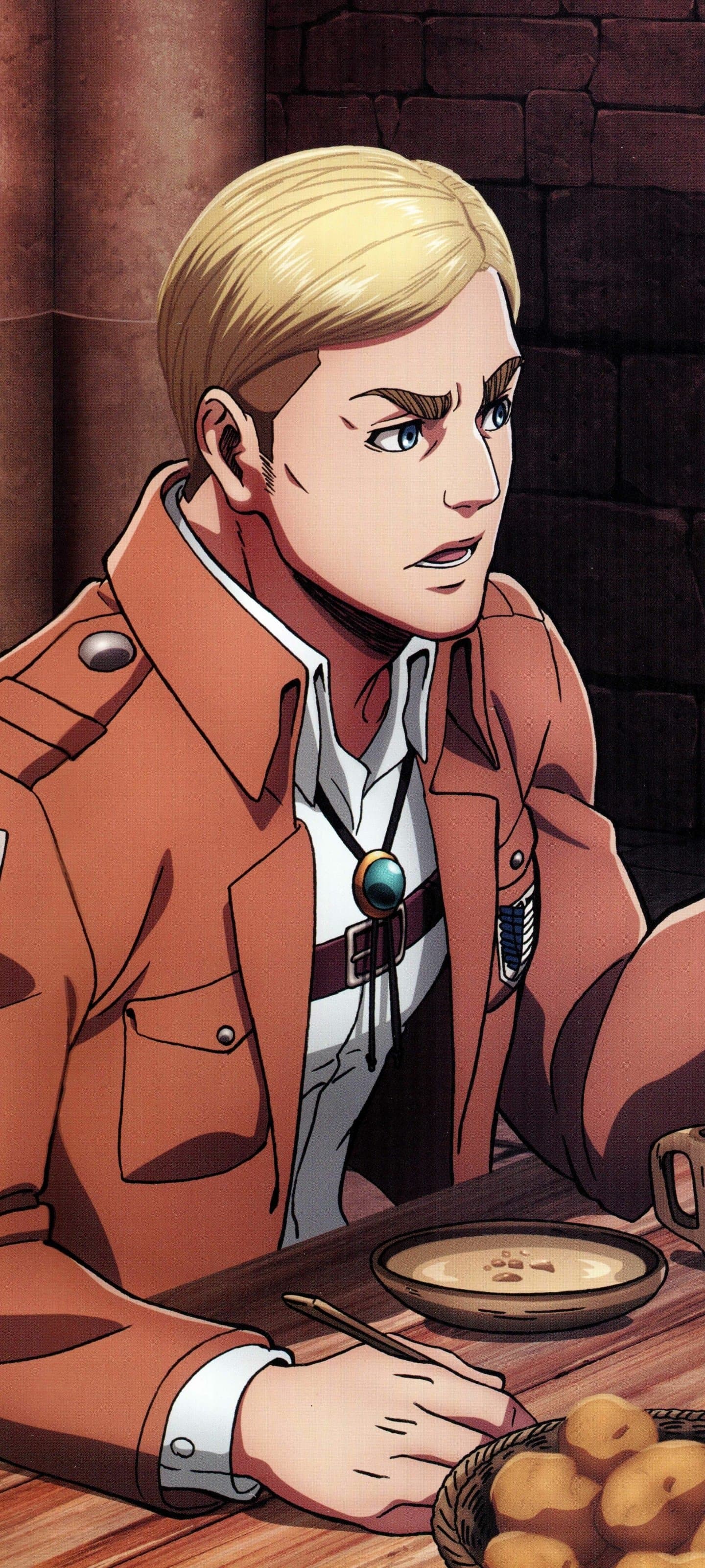 The image features Erwin Smith, a tall man with neatly parted blonde hair and thick eyebrows, wearing the standard Survey Corps uniform. He is dressed in a tan military jacket over a white button-down shirt, accessorized with a distinctive bolo tie featuring a green gemstone. The character is seated at a rustic wooden table, captured in a three-quarter profile with a serious and focused expression. In front of him sits a simple meal consisting of a bowl of soup and a basket of bread rolls, suggesting a moment of respite or a strategic meeting. The background consists of a dark, textured stone wall, typical of a medieval or historical interior setting. The art style utilizes sharp line work and classic cel-shading, creating a grounded and mature atmosphere consistent with a high-stakes military drama.