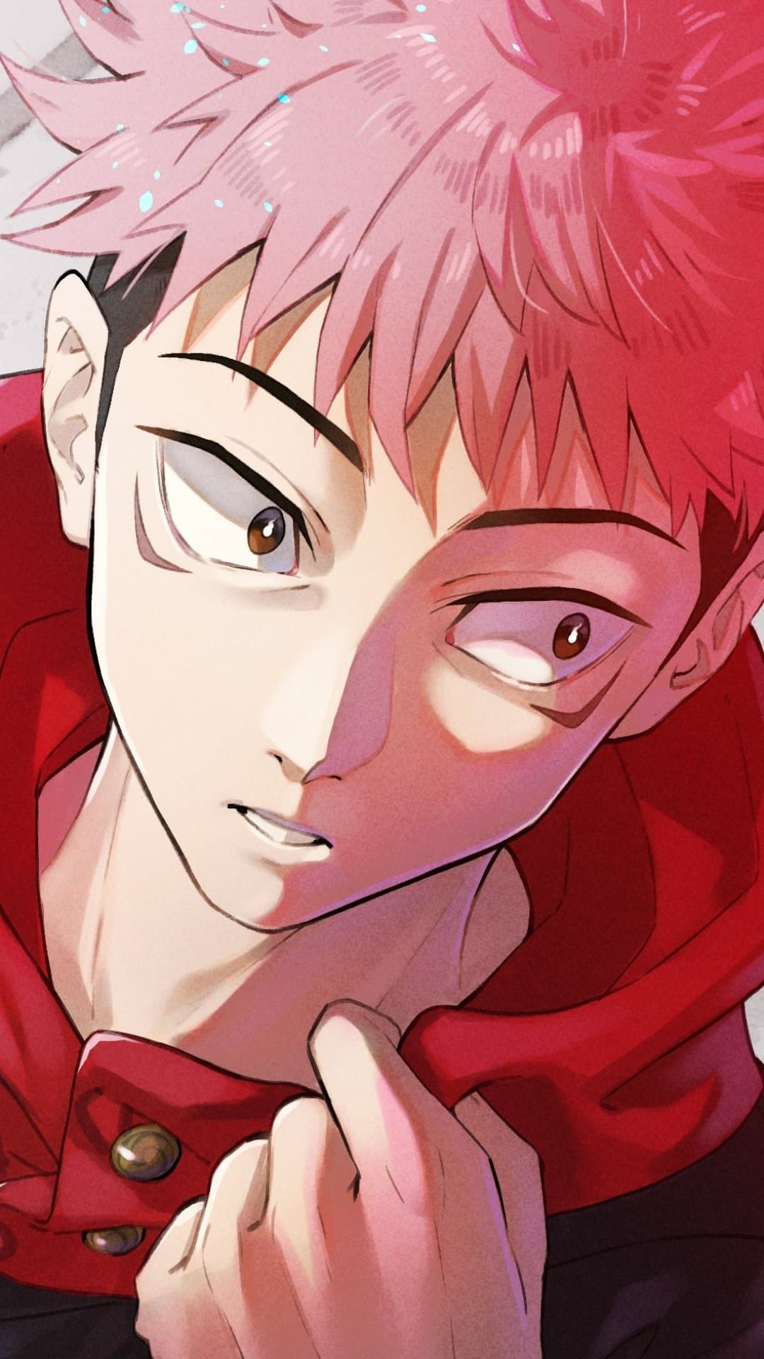 The image features a close-up portrait of Yuji Itadori, characterized by his signature spiky pink hair with dark undercut and light brown eyes. He is wearing his standard Jujutsu High uniform, consisting of a dark high-collared jacket with a prominent red hood and gold buttons. The character is depicted in a dynamic, slightly tilted pose, looking off-camera with a focused and somewhat intense expression. The background is a minimalist, textured light grey, which allows the vibrant pink and red tones of the character to stand out. The art style utilizes sharp line work and a combination of cel-shading and soft gradients to create depth, particularly on the face and clothing folds. The overall atmosphere is one of determination and quiet intensity, capturing a serious moment for the protagonist.